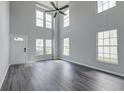 Spacious living room featuring high ceilings, abundant natural light, and modern gray wood flooring at 2076 Wild Flower Ln, Charleston, SC 29414