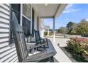 View of the front porch with rocking chairs and greenery, offering a relaxing outdoor space at 271 Palmetto Walk Dr, Summerville, SC 29486