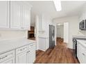 Bright kitchen featuring white cabinetry, countertops, stainless appliances, and hardwood floors at 317 Commons Way, Goose Creek, SC 29445