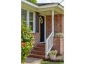 Inviting front porch with brick steps, white railings, and decorative plants at 392 Cross St, Charleston, SC 29407