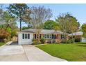 Charming home with brick facade, shutters, manicured lawn, and concrete driveway at 392 Cross St, Charleston, SC 29407