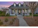 Inviting two-story home with a covered porch, complete with columns, a ceiling fan, and an American flag at 406 Summers Dr, Summerville, SC 29485