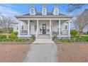 Charming two-story home with a welcoming front porch, columns, dormer windows, and manicured landscaping at 406 Summers Dr, Summerville, SC 29485