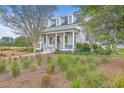 Attractive two-story home with a large covered porch, ceiling fan, and well-maintained landscaping at 406 Summers Dr, Summerville, SC 29485
