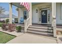 Inviting front porch with rocking chairs, a decorative door wreath, and charming details at 4303 Misty Hollow Ln, Ravenel, SC 29470