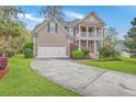 Charming two-story home with a spacious front yard, a two-car garage and a welcoming double-decker porch at 5411 Nesting Pl, North Charleston, SC 29420