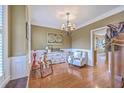 Bright living room showcasing a chandelier, hardwood floors, and classic wall trim at 5411 Nesting Pl, North Charleston, SC 29420