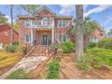 Beautiful two-story brick house with a covered porch, balcony, manicured landscaping, and charming details at 8795 E Fairway Woods Cir, North Charleston, SC 29420