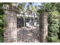 Private backyard oasis with brick patio, iron gate, lounge chairs and lush landscaping at 106 Beaufain St, Charleston, SC 29401