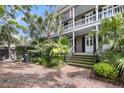 Charming two-story home with a double porch, lush landscaping and brick steps at 106 Beaufain St, Charleston, SC 29401