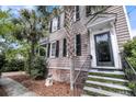 Charming two-story home features front door entrance, steps and landscaped yard at 106 Beaufain St, Charleston, SC 29401