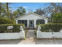 Inviting front exterior with white siding, lion statues, a screened in porch, and neat landscaping at 109 Gerideau St, Walterboro, SC 29488