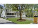 Inviting home exterior featuring a well-maintained lawn, attractive landscaping, and a cozy front porch at 1133 Mount Batten Dr, Hanahan, SC 29410