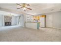 Open living area featuring fireplace, ceiling fan, and kitchen with tile floors and cabinets at 115 Foxborough Rd, Goose Creek, SC 29445