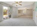 Spacious living room with ceiling fan, sliding door, and view into kitchen area at 115 Foxborough Rd, Goose Creek, SC 29445