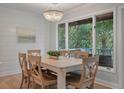 Inviting dining area with a wood table, chandelier, and a wall of windows providing picturesque backyard views at 1330 Sea Elder Dr # C, Kiawah Island, SC 29455