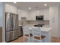 Bright kitchen with white cabinets, stainless steel appliances, island with seating, and ample storage, perfect for Gathering meals at 1330 Sea Elder Dr # C, Kiawah Island, SC 29455