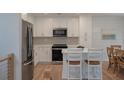Modern kitchen with stainless steel appliances, white cabinets, subway tile backsplash, and eat-in island with barstool seating at 1330 Sea Elder Dr # C, Kiawah Island, SC 29455