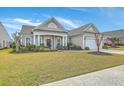 Well-maintained single-story home with lush landscaping, an inviting covered porch, and an attached garage at 145 Billowing Sails St, Summerville, SC 29486