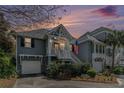 Charming two-story home boasts landscaped yard, white trim, and an inviting entrance at dusk at 1501 Sea Palms Cres, Mount Pleasant, SC 29464