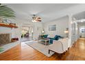 Inviting living room with a blue sofa, fireplace, hardwood floors, and view to the outdoor porch at 1515 Wakendaw Rd, Mount Pleasant, SC 29464