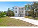 Beautifully landscaped home with a long driveway leading up to the attached garages and front entry at 1615 Macoma Rd, Mount Pleasant, SC 29466