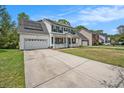 Inviting two-story home with a covered front porch, solar panels, and a long driveway at 176 Hainsworth Dr, North Charleston, SC 29418