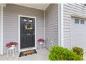 Inviting front door adorned with a seasonal wreath and potted flowers creating a warm welcome at 178 Buchanan Cir, Goose Creek, SC 29445