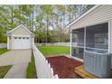 View from the screen porch looking at the backyard, detached garage and white picket fence at 1833 Hubbell Dr, Mount Pleasant, SC 29466