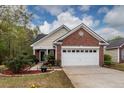 Traditional home with manicured lawn, flower beds, brick facade, and two-car garage at 201 Island Green Rd, Goose Creek, SC 29445