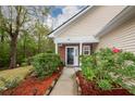 Inviting front porch with manicured landscaping, brick accents, and a neatly paved walkway at 201 Island Green Rd, Goose Creek, SC 29445