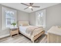 Cozy bedroom with neutral tones, two bright windows, a ceiling fan and beautiful wood-look flooring at 2325 Sorentrue Ave, North Charleston, SC 29405