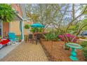 Relaxing patio area with comfortable chairs, a vibrant umbrella, and beautifully landscaped surroundings at 2952 Sweetleaf Ln, Johns Island, SC 29455