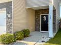 Inviting front porch with stone accents and a black door with a pineapple wreath and the address number 449 at 449 Whispering Breeze Ln, Summerville, SC 29486