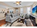 Spacious living room featuring hardwood floors, a large sectional sofa, and bright natural light from multiple windows at 449 Whispering Breeze Ln, Summerville, SC 29486