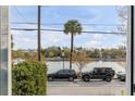 Scenic lake view framed by a window, showcasing waterfront living with cars parked nearby at 49 Ashley Ave, Charleston, SC 29401