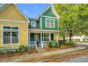 Attractive green home with a welcoming front porch, complemented by well-maintained landscaping at 5132 E Liberty Park Cir, North Charleston, SC 29405