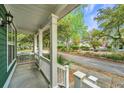 Inviting front porch with classic white columns offering a serene view of the street and foliage at 5132 E Liberty Park Cir, North Charleston, SC 29405