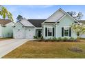 Charming light blue home featuring a three car garage and well manicured landscaping at 552 Marsh Cv Cir, Summerville, SC 29486