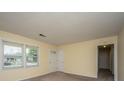 Spacious, carpeted living room featuring a white front door, a view of the exterior, and ample natural light at 7079 N Kenwood Dr, North Charleston, SC 29406