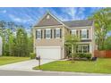 Charming two-story home featuring a well-manicured lawn, neutral siding, black shutters, and an attached two-car garage at 7818 Expedition Dr, North Charleston, SC 29420