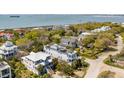 Scenic aerial view of homes near the water, showing the house with a rooftop deck and solar panels at 904 Middle St, Sullivans Island, SC 29482
