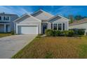 Inviting home exterior with tidy landscaping and a private driveway leading to an attached garage at 9723 Flooded Field Dr, Ladson, SC 29456