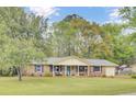 Charming brick home with blue shutters, manicured lawn, covered porch, and inviting curb appeal at 103 Arbor Rd, Summerville, SC 29485