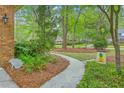 A well-maintained sidewalk leads up to the home, set amid mature trees and manicured landscaping at 104 Huckleberry Ln, Summerville, SC 29485
