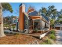 Beautiful blue house featuring a screened porch, wood accents, and mature trees surrounding the home at 1056 Wharf Indigo Pl, Mount Pleasant, SC 29464