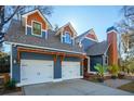 Charming exterior showcasing a two-car garage, wood accents, blue siding and a lovely manicured lawn at 1056 Wharf Indigo Pl, Mount Pleasant, SC 29464
