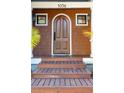 Inviting front door with beautiful wood detailing, framed by classic lantern lights and small windows at 1056 Wharf Indigo Pl, Mount Pleasant, SC 29464