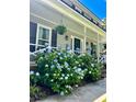 Inviting covered porch with white railings and vibrant hydrangea bushes, offering a relaxing outdoor space at 106 Dunmow Dr, Summerville, SC 29485