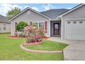 Close-up of a home's landscaped yard with vibrant azalea bushes and red mulch at 1302 Camden Xing, Hanahan, SC 29410
